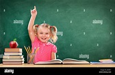 Feliz, la niña levantando la mano en el aula Fotografía de stock - Alamy