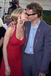 a man and woman kissing each other on the red carpet