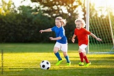 Kids play football. Child at soccer field. Stock Photo | Adobe Stock