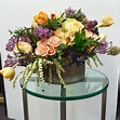 a vase filled with flowers sitting on top of a glass table