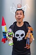 a man is holding two toy rockets and a skull on his head