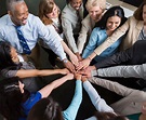 Diverse team of professionals with hands in teamwork huddle - GMS ...