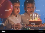 Cute little twins blowing out candles on birthday cake at party Stock ...