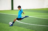 Chicos jugando al fútbol en el campo de práctica de fútbol | Foto Premium