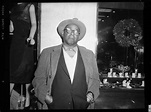 Portrait of James “Jimmy” Bates standing in front of wall, with store ...