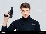 Portrait of handsome young man holding a gun Stock Photo - Alamy