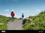 People walking along a path in windy weather Stock Photo - Alamy