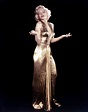 Marilyn monroe usando un vestido de color dorado y levantando los ...