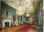 an ornate room with chandeliers, chairs and paintings on the walls is shown