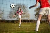 Girl kicking Football ball into goal - Stock Photo - Dissolve