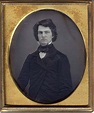 Gilt-framed daguerreotype of a man with a full head of wavy hair. He ...