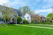 Row of traditional suburban homes with lush green front lawns in nice ...