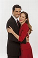 a man in a suit and tie hugging a woman wearing a red dress with her ...