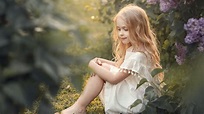 Cute Little Girl Is Sitting On Grass Looking Down Wearing White Dress ...