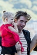 Robert Pattinson holds a baby at the San Sebastian Film Festival