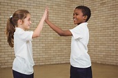 Happy pupils giving each other a high five Photo | Premium Download