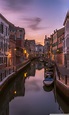 the boats are parked along the side of the canal at sunset or dawn in ...