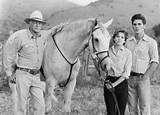 an old black and white photo of three people standing with a horse in a ...