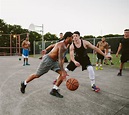 Two young men playing street basketball