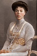 an old photo of a woman sitting at a table with a cup and saucer