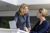 Two women talking at desk in office stock photo