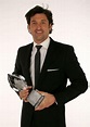 a man in a suit holding an award