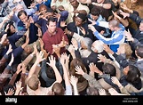 Young man surrounded by crowd Stock Photo - Alamy