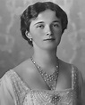 an old black and white photo of a woman in a dress with pearls on her neck