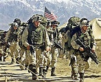 Soldados estadounidenses armados y con mochilas caminan por una base ...