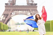 Francia - mujer de la bandera francesa por la torre Eiffel, París 2024