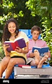 Teenagers reading books outdoors Stock Photo - Alamy