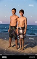 Two boys standing on beach at sunset Stock Photo, Royalty Free Image ...
