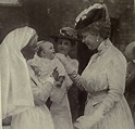 Another rare" image of Queen Mary smiling , this time at a baby, during ...