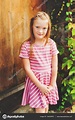 Outdoor portrait of adorable 6 year old girl wearing pink stripe dress ...