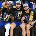 three basketball players sitting on the bench with their trophies in ...