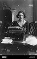 Flora Payne Whitney Miller, three-quarter length portrait, seated at typewriter, facing front ...
