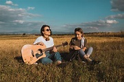 Dos Hermanas Gemelas Feliz Tocando La Guitarra En La Naturaleza En Un ...
