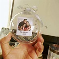 a hand holding a glass ornament with a photo on it