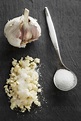 Garlic with salt in spoon, close up stock photo