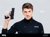 Portrait of handsome young man holding a gun Stock Photo - Alamy