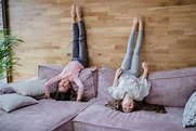 Foto Irmãzinhas felizes fazendo a cabeça em pé em um sofá em casa ...
