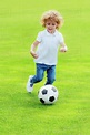 Cute happy little boy playing soccer on green grass at park - Stock ...