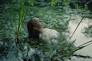 A Woman In A White Dress On The Surface Of A Swamp Water In The Forest ...