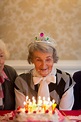 Senior woman celebrating birthday with her friends at home — 80s, happy ...