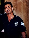 a man wearing a police uniform standing in front of a wooden wall