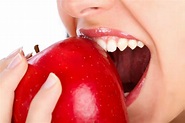 Woman Biting Red Apple – Hollistic-Cares