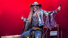 Rob Zombie Is Wearing Blue Dress And Cap In Red Wall Background HD Rob ...