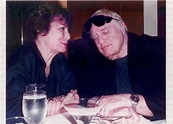 an old man and woman sitting at a table