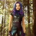a woman with purple hair standing in the middle of a forest wearing ...