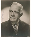 an old black and white photo of a man in a suit with a flower tie
